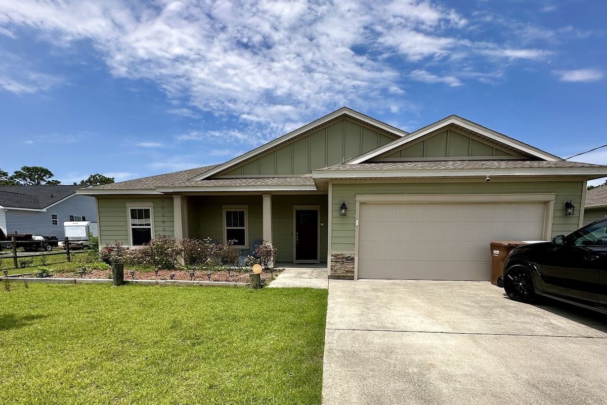 Front of Timber Bliss with green lawn and front porch