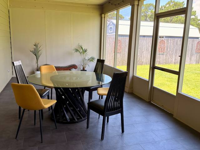 Screened porch dining area overlooking the fenced yard
